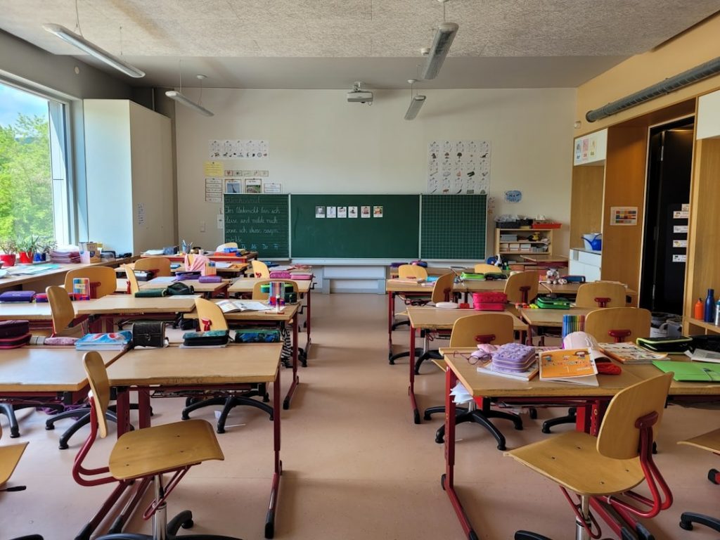 Klassenzimmer mit Tischen und Tafel